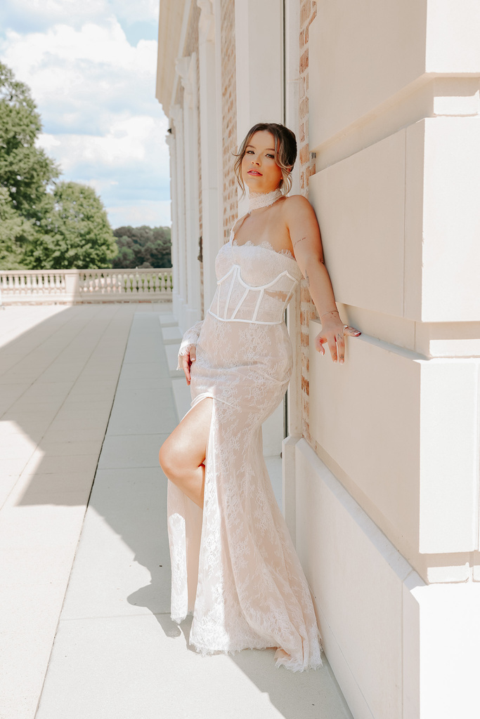 a person in a wedding dress leaning against a wall