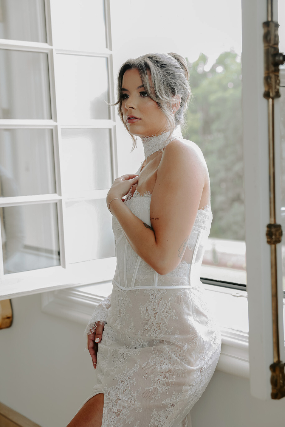 a person in a wedding dress standing by a window