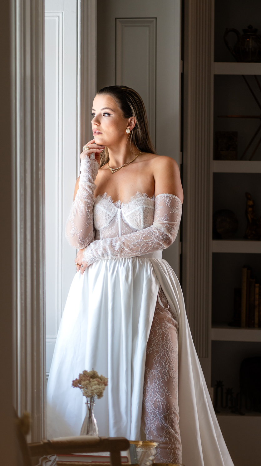 a person in a wedding dress standing in front of a window