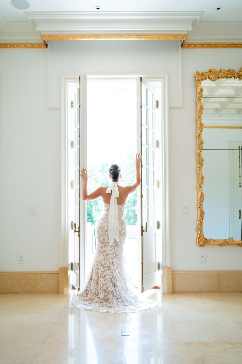 a person in a floral wedding dress standing in front of an open door