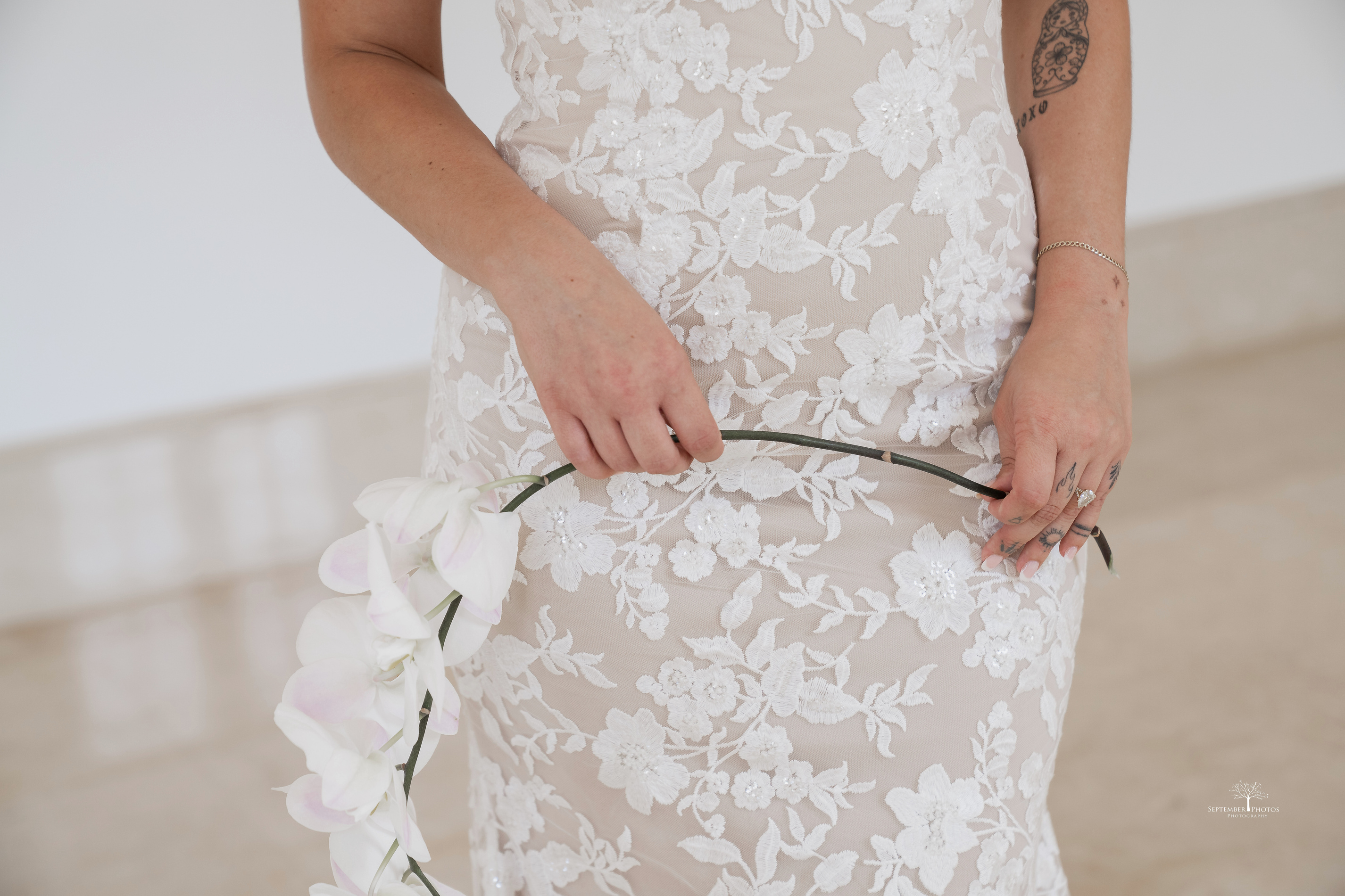 a person in a wedding dress holding an orchid