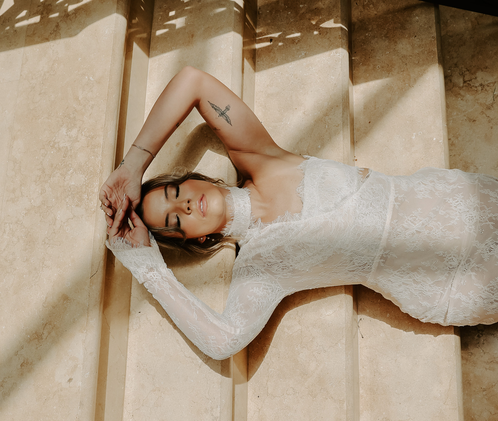 a model in a wedding dress laying on the stairs