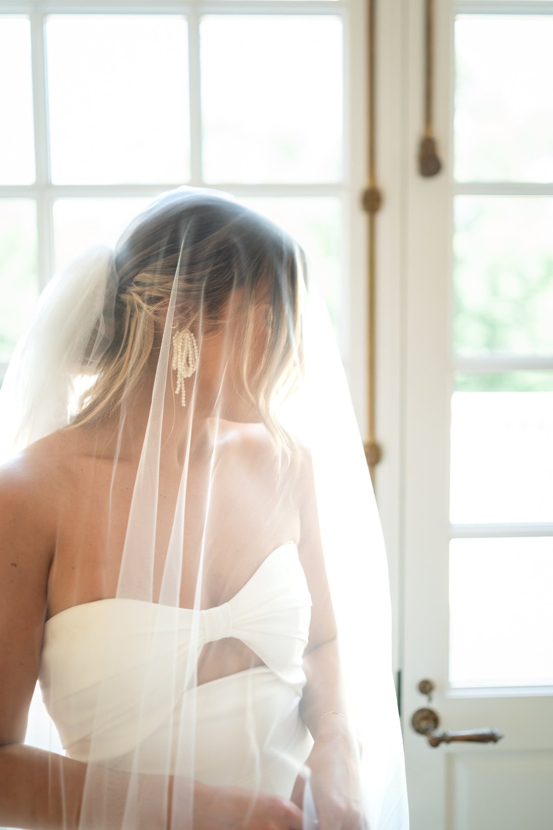 a person in a wedding dress standing in front of a window